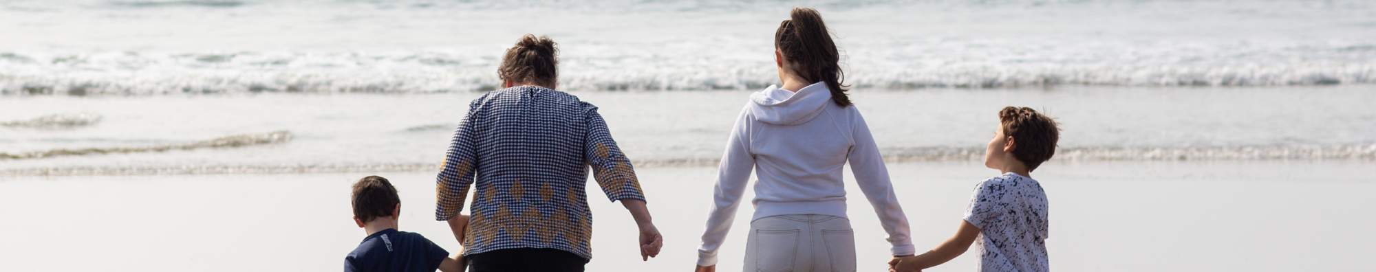 Family walking away from the camera on the beach