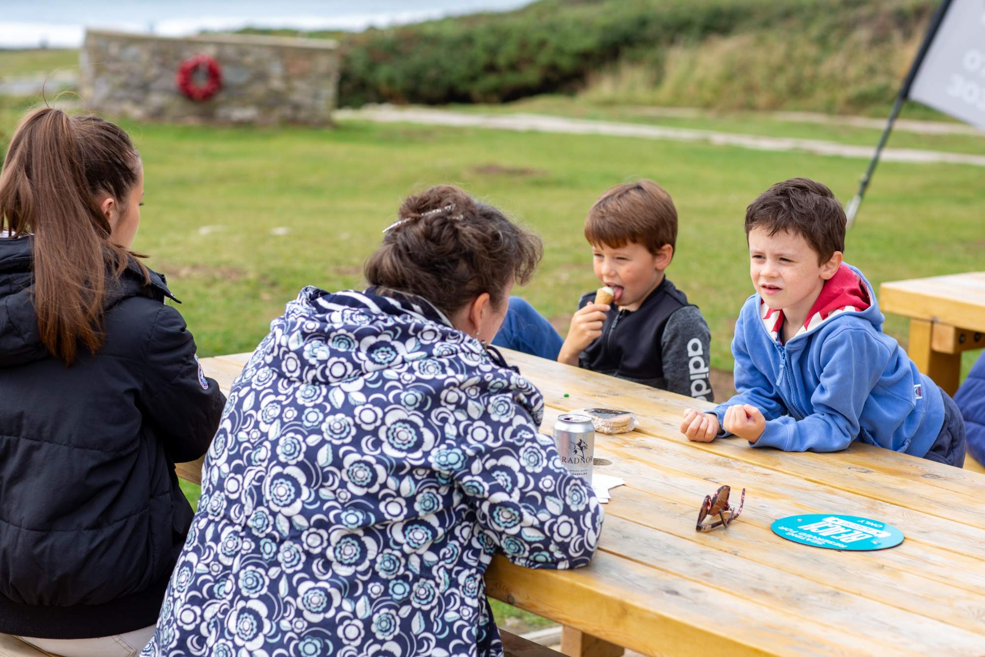 Family sitting outside at table eating ice cream