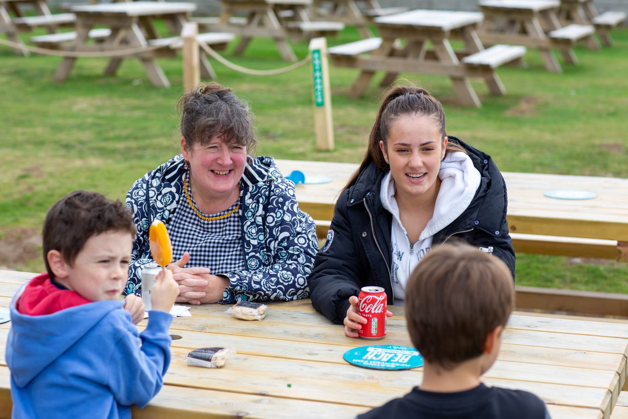 Family eating lunch at a bench in the park