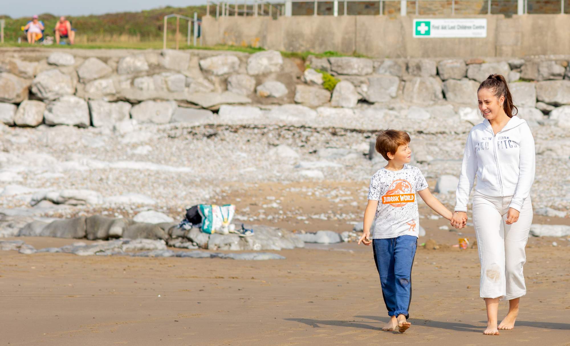 Brother and sister on the beach holding hands