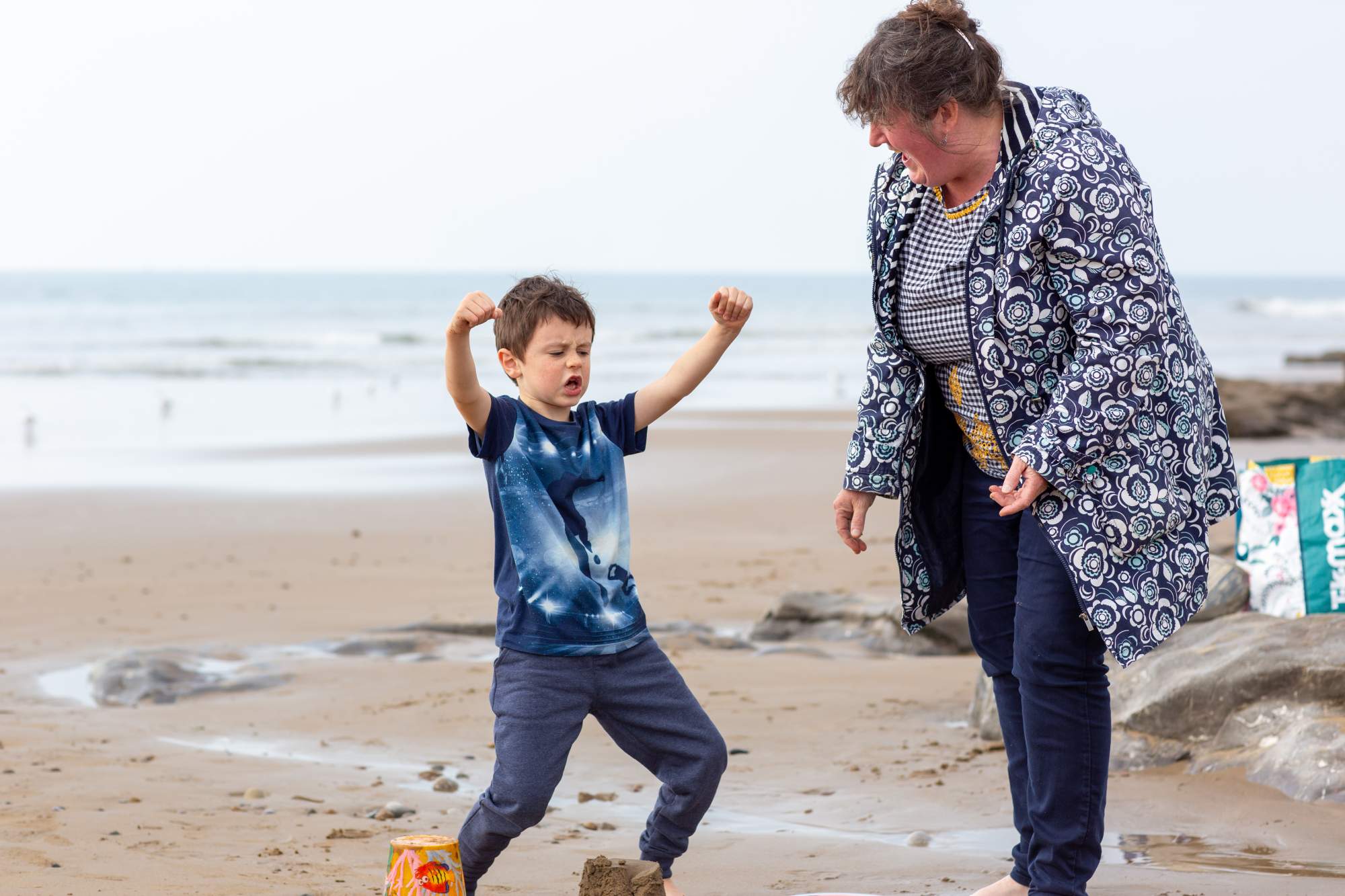Boy raises arms in victory while mum supports